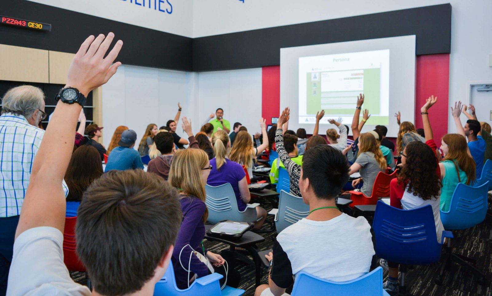 Students raising hands at Mission Fed JA Finance Park classroom